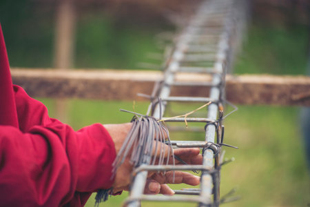 Construction Worker hands using pincer pliers iron wire. Outdoor Worker using wire bending pliers, construction work. Men hands bending cutting steel wire fences bar reinforcement of concrete workの写真素材