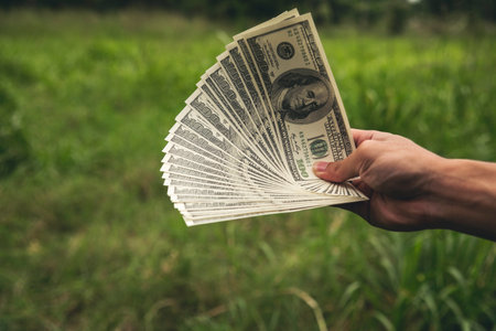 Close up hands giving money payment. Hands holding dollar bill financial economy business people.の写真素材