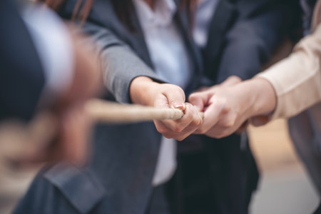 Tug of war Group of business people Hands pulling rope symbol team unified teamwork Partnership Concept. Businesswoman Team holding hands together partnership leader teamwork. diversity competitionの写真素材