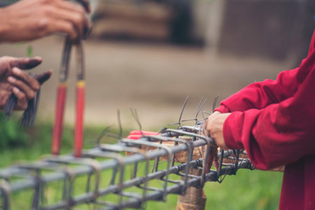 Construction Men hands bending cutting steel wire fences bar reinforcement of concrete work. Worker hands using pincer pliers iron wire. Outdoor Worker using wire bending pliers, construction workの写真素材