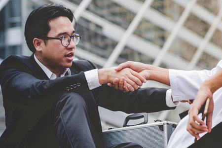Arab Businessman shaking hands together. Teamwork business partner wear Muslim dress Shake Hands with Partnership Concept. Success UAE diversity people trust make commitment by handshakeの写真素材