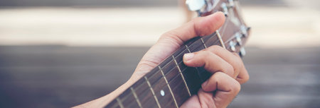 Handsome men playing acoustic guitar outdoor in green park. young man playing acoustic guitar music...
