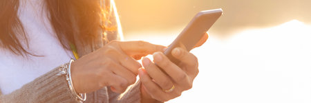 Banner Woman hands holding mobile phone outdoor surfing internet online technology lifestyle. Close up woman hand using smartphone gadget text message panoramic with copy space. Technology lifestyleの写真素材