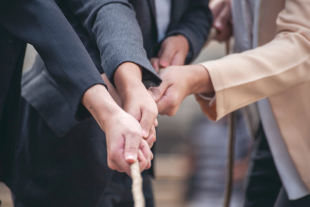 Tug of war Businesswoman Team holding hands together partnership leader teamwork. Group of business people Hands pulling rope symbol team unified teamwork Partnership Concept. diversity competitionの写真素材
