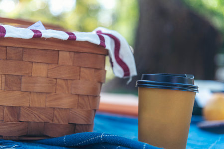 Picnic basket croissant bread Bacon egg cheese brunch box food coffee cup orange juice in wood wicker box on red Blanket. whole Wheat bread bakery fruit food and drinks green park outdoor lifestyleの写真素材