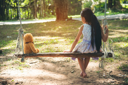Happy Child hug teddy bear in green park playground. Teddy bear best friend for little kids cute girl. Autism happy funny playing together on playground in happiness family feel love and warm hugsの写真素材