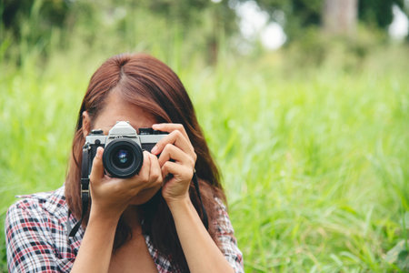 Close up hands Asian Women look at dslr digital camera vintage film style take a photo. Professional...