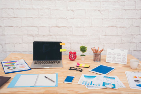 Meeting room Office laptop business financial document chart , graph on wooden table with coffee cup. Flat lay notebook computer laptop on office desk. No people business graph chart on meeting tableの写真素材