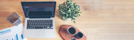Banner Top view office desk laptop and coffee cup on wood table copy space.  Panorama tabletop notebook laptop coffee cup for officer display empty space wooden background workspace full banner designの写真素材