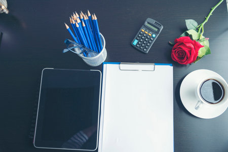 Top view office desk smart tablet document paper, coffee cup roses on wood table with copy space....