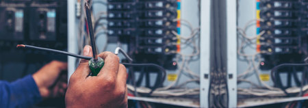 Banner Electrical mechanic technician check wire electric cabinet. Inspector men hands working maintenance service. Electrician circuit repair operation. Men hands fix breaker with copy spaceの写真素材