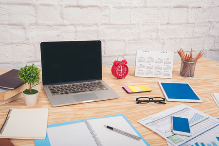 Meeting room Office laptop business financial document chart , graph on wooden table with coffee cup. Flat lay notebook computer laptop on office desk. No people business graph chart on meeting tableの写真素材