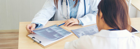 Banner hands of two women doctor medical lab discussing together healthcare teamwork. Panorama Two asian women doctors meeting write prescription medical clinic office using laptop with copy space.の写真素材