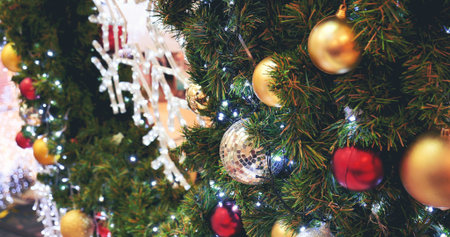Colourful glittering baubles ornament ball decorated christmas tree on holiday winter xmas happy new year festival celebration. Red, gold, silver ball on Christmas tree. Merry Christmas happy new yearの写真素材