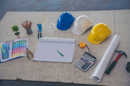 construction engineer office desk architect workplace. engineer drawing objects table with meter, blueprint, hard hat engineering stuff on desk. Designer Objects drafting workplace on wooden table.の写真素材
