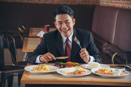 Businessman eat Steak having lunch at a restaurant. Ribs eye steak with mashed potato, salad cream French fries Barbecue Grill and Spaghetti, Happy man sitting have dinner enjoying foodの写真素材