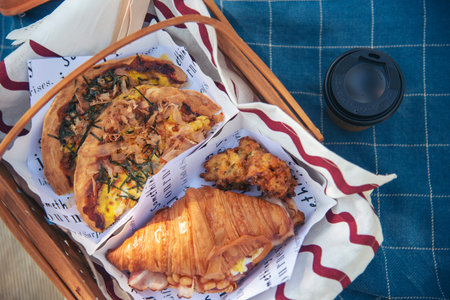 Picnic basket croissant bread Bacon egg cheese brunch box food coffee cup orange juice in wood...