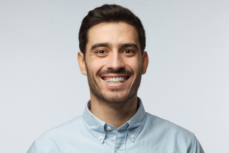Stylish bearded business man smiling to camera, having pleased expression and cheerful look. Positive emotions concept.の写真素材