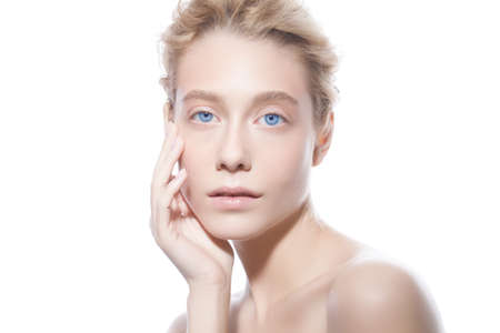 Beautiful model woman face with blue eyes and blond hair looking at camera, isolated on whiteの写真素材