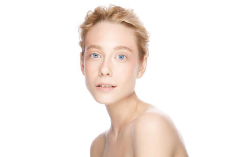 Beauty woman face with blue eyes and blond hair looking at camera, isolated on whiteの写真素材