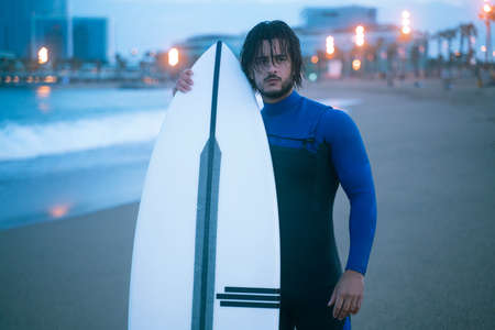 Surfer standing and holding his surf board, ready for surfing at Barcelona beachの写真素材