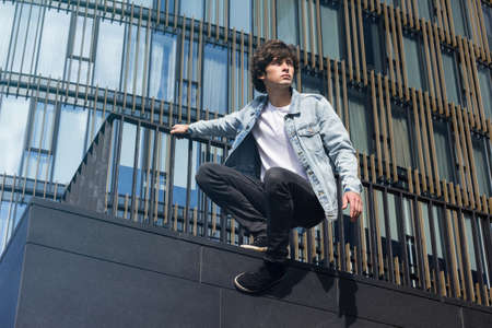 Young guy in jeans doing parkour and stunts in the cityの写真素材
