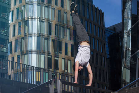 Active handsome male person making stunts in the city
