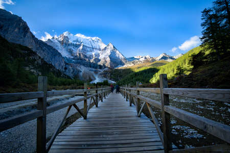 snow capped mountains with wooden bridge sceneryの写真素材