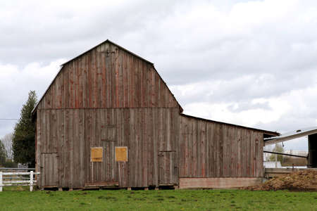 brown barn on a cloudy day in the country.の写真素材