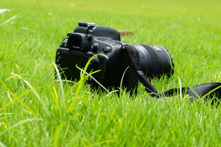 Rear view of camera on grass backgroundの写真素材