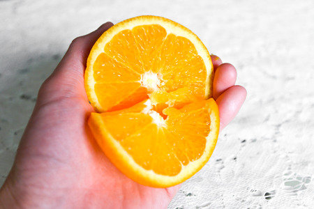 Orange in a female hand isolated on a white background