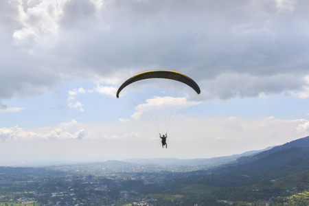 Paraglider launching from the ridge with a yellow and white canopy. The shot is taken right after...