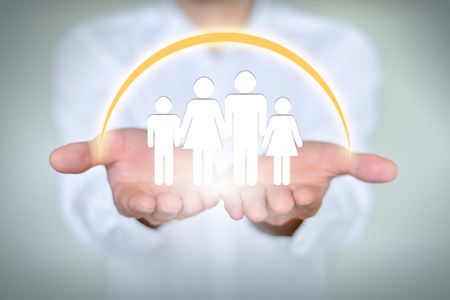 People, family, charitable organizations and nursing concepts, close-up of two hands holding a family of fourの写真素材