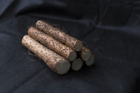 Yam placed on the background of black linenの写真素材