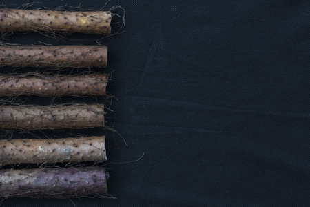 Yam placed on the background of black linenの写真素材