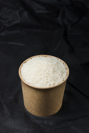 rice in a container on dark backgroundの写真素材