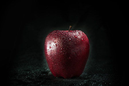 A red apple is isolated in a black backgroundの写真素材