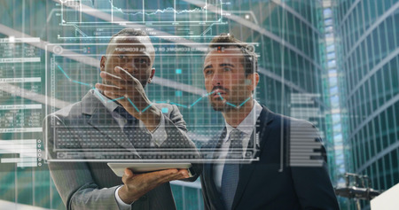 Two businessmen discussing economics and hand touches themselves to the financial holographic trends in the holography appearing in front of him. Concept of: increased reality and futureの写真素材