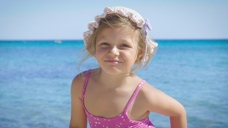 Cute little girl in panama, sun protection cream, background of sea. Concept: children, childhood, summer, freedom, kids, baby, summer.の写真素材