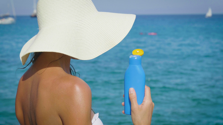 Beautiful girl rinsing her body in a white bikini smiling, sunglasses, background. Concept: beauty, vacation, spa procedures, bio-cream spa, summer.の写真素材