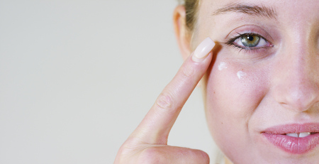 Without makeup, smearing face, cream, on a white background.Concept: natural beauty, youth, skin care, always young, love yourself.の写真素材