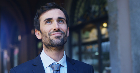 A man in a suit, looks in the room and smiles proud and sure of himself. Concept of politics, business, finance, banking, insurance and testimonials for political campaign.の写真素材