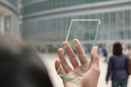 The hand of a woman in suits, uses a futuristic glass with the latest advanced holographic technology. Concept of: future, technology, smartphone, augmented realityの写真素材