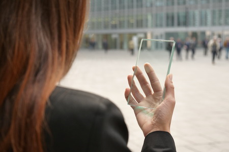 The hand of a woman in suits, uses a futuristic glass with the latest advanced holographic technology. Concept of: future, technology, smartphone, augmented realityの写真素材
