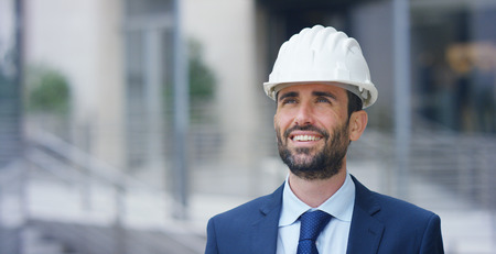 Engineer with the construction helmet, smiling in the background. Concept: construction, business, future, passion and engineering.の写真素材