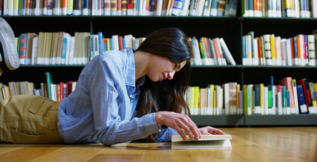 A beautiful young woman studying in a happy and carefree library. Concept: educational, portrait,...