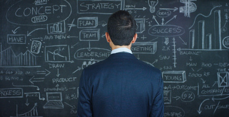 Portrait of a beautiful business man, a marketing teacher, thinking about new ideas and strategies, on a black background. Concept: career growth, growth chart, successful girl, marketing, ideas.の写真素材