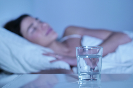 A woman before going to bed, stomach ache and flu. Concept of: illness, wellness, medicines and pharmacyの写真素材