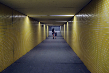 A woman and a daughter are walking in a corridor of the metro station.の写真素材