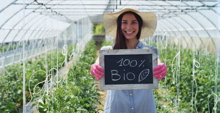 A beautiful girl in a straw hat and in pink gloves, holds a shovel for planting, in a greenhouse. Concept: bio products, natural products, fresh, delicious, fruits, vegetables, grow water plants A beautiful girl in a straw hat and in pink gloves, holds a shovel for planting, in a greenhouse. Concept: bio products, natural products, fresh, delicious, fruits, vegetables, grow water plants
